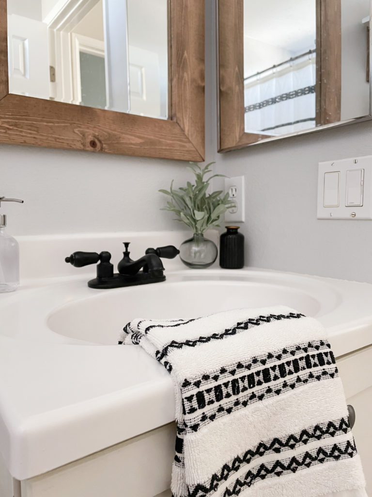 Vanity makeover with white Appliance Epoxy Spray. Faucet sprayed with matte black spray paint too. And mirror reframed with rustic wood frame. 