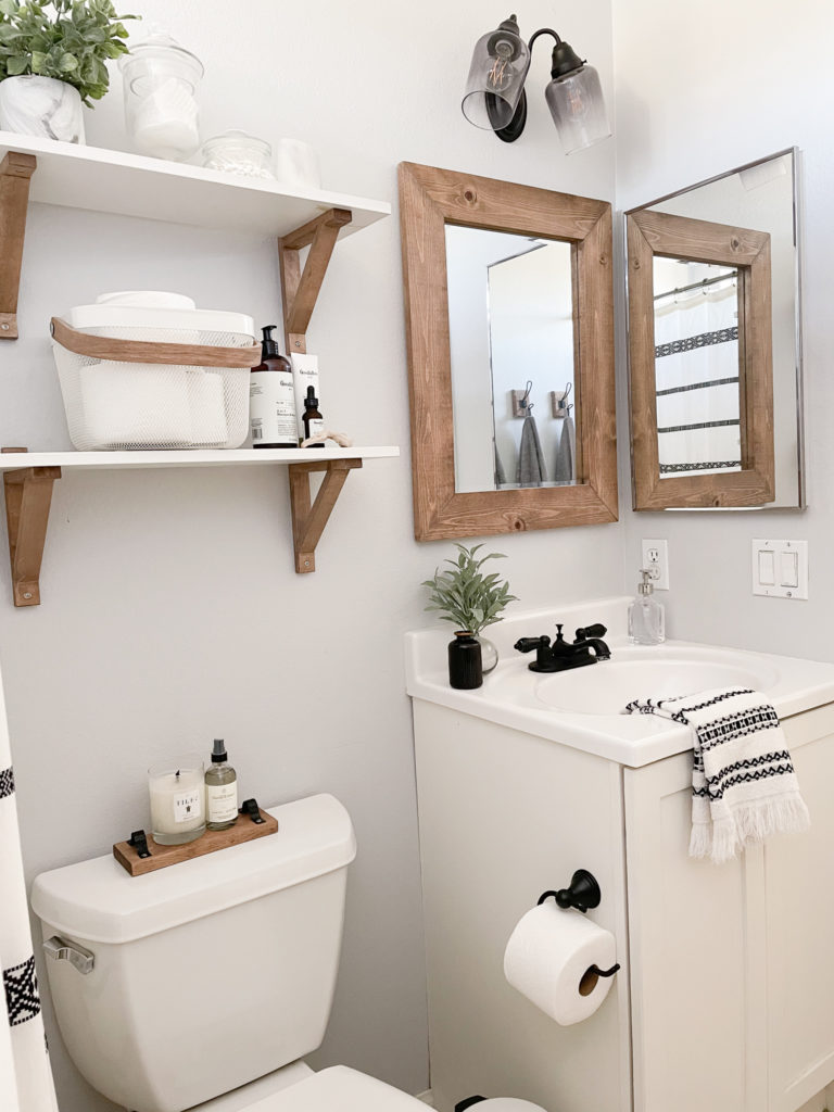 Bathroom makeover - Pulled back view of the updated bathroom Vanity, faucet, Mirror, and shelves. 