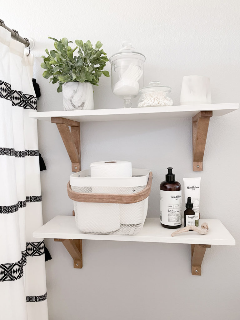 Farmhouse styled bathroom shelves with marbled pot faux plant, apothecary jars, ikea basket and Goodfellow cosmetics. 