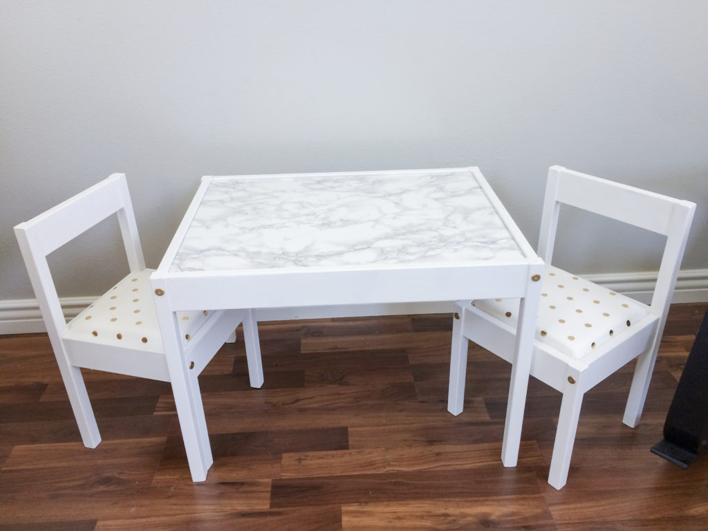 Ikea LATT table and chair hack for girls room with white paint, white & gold polka dot cushions, and marble tabletop. 