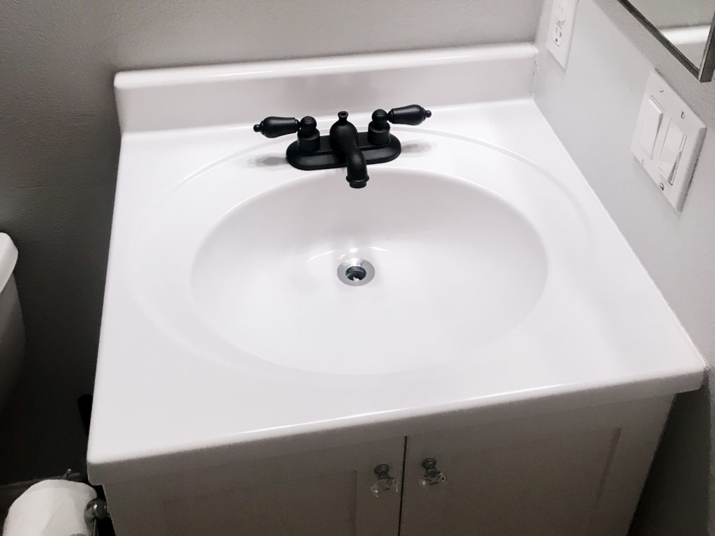 Vanity makeover with white Appliance Epoxy Spray. Faucet sprayed with matte black spray paint too. 