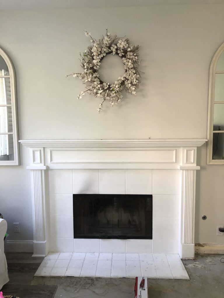Preview of fireplace and mantle before remodel - builder grade trim and moulding with outdated white tile hearth. 