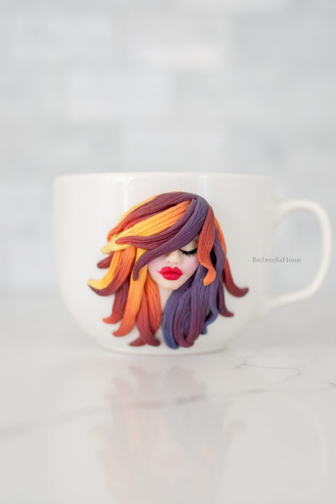 mug art: 3D image of woman's face made out of polymer clay with colorful ombre hair.