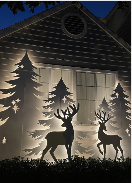Christmas Silhouette decor displaying 4 Christmas trees and 2 Reindeer cut out of plywood and back lit with holiday lights.